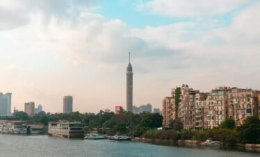 Beautiful view of Cairo skyline featuring the iconic Cairo Tower and downtown architecture along the Nile River.